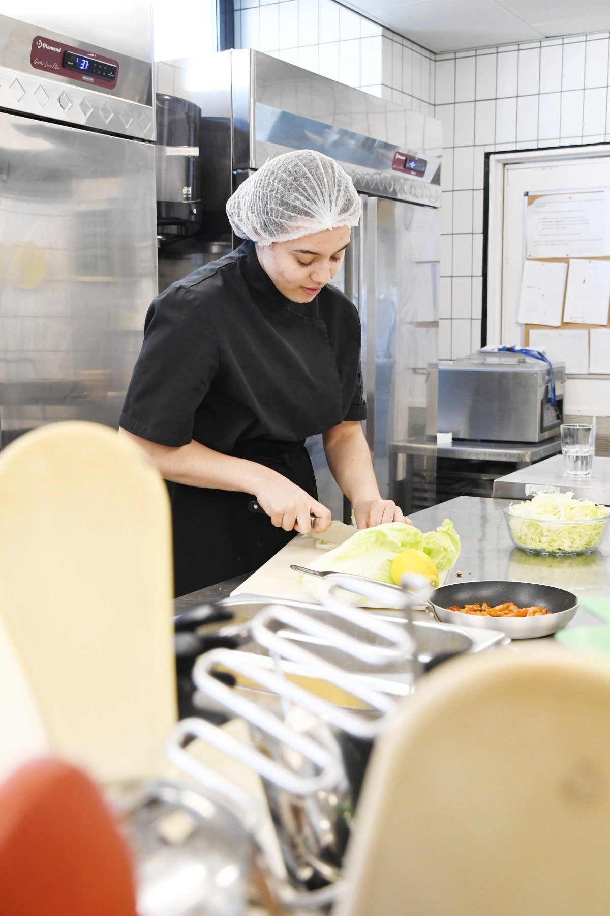 une photo qui montre une jeune élève en cuisine - en formation chez CEFA de Bruxelles- en atelier cuisine
